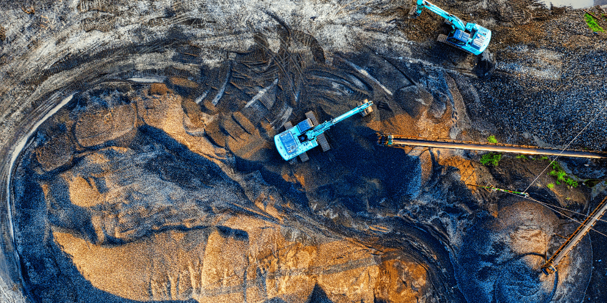 Aerial view of excavation machinery working on a gravel site with patterns in the earth