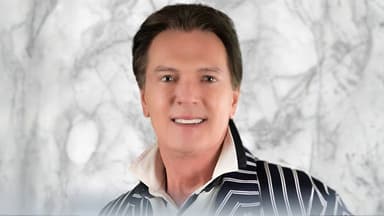 Greg Gunter, a luxury real estate broker, smiles in a striped jacket, embodying professionalism in San Miguel de Allende.